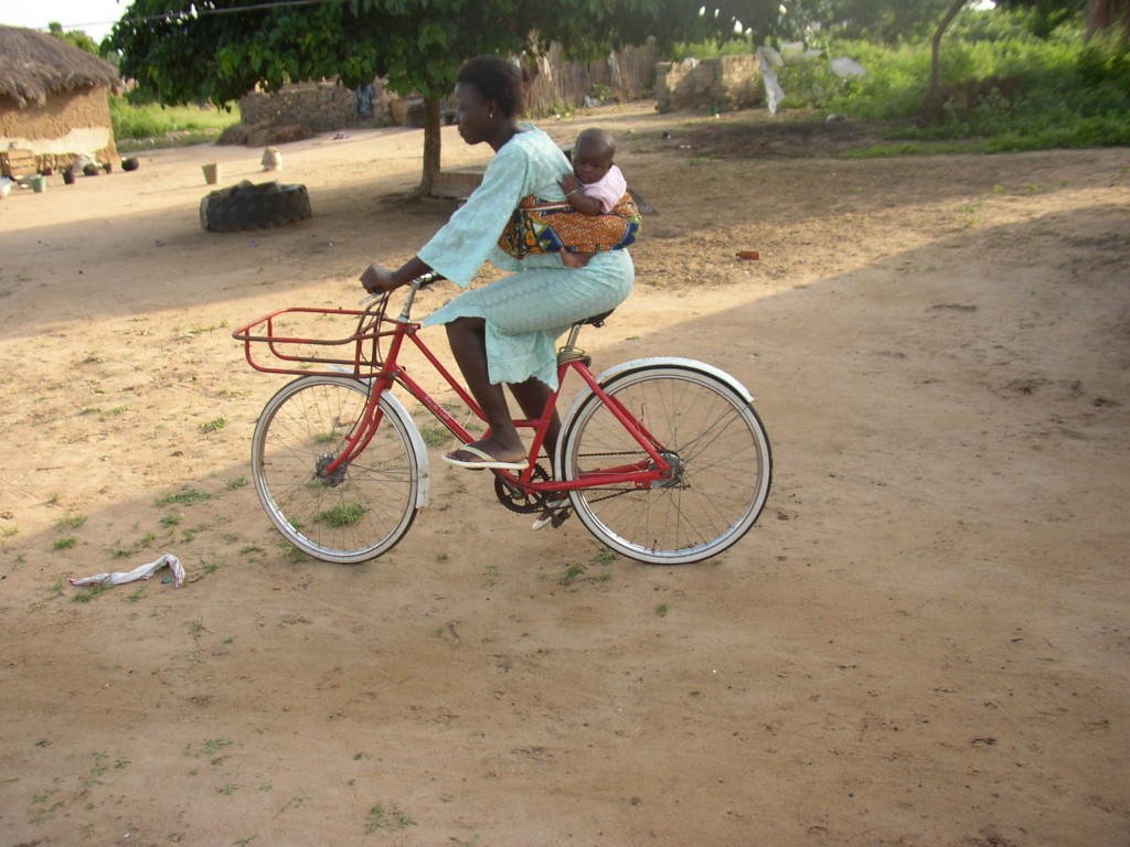 Ester, woman with her baby and bike in Ghana, Africa